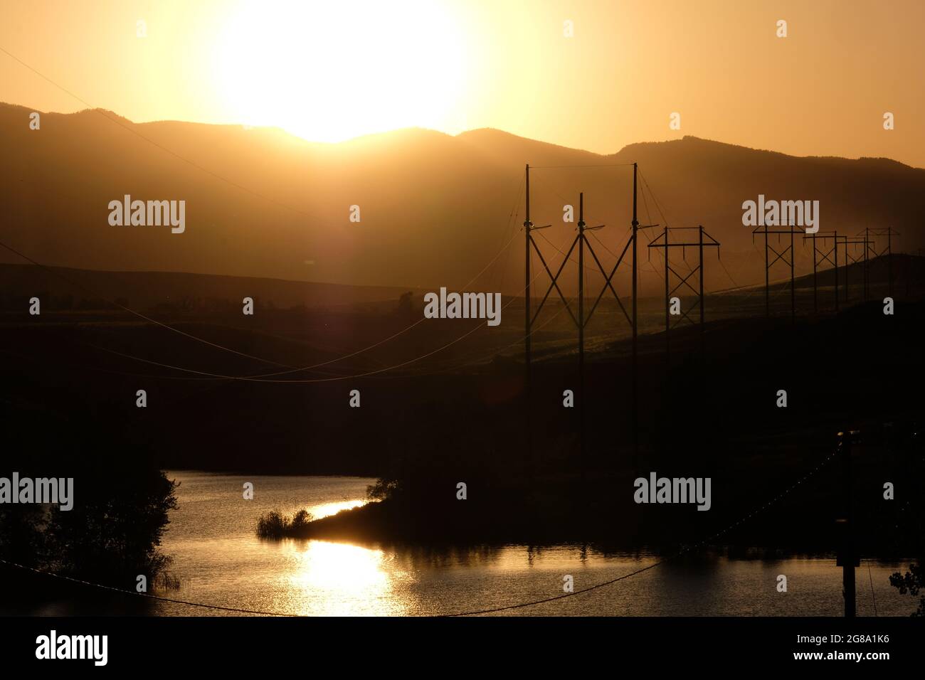 Tours de transmission électrique et fils au coucher du soleil près du lac DeSmet, Buffalo, Wyoming. Banque D'Images