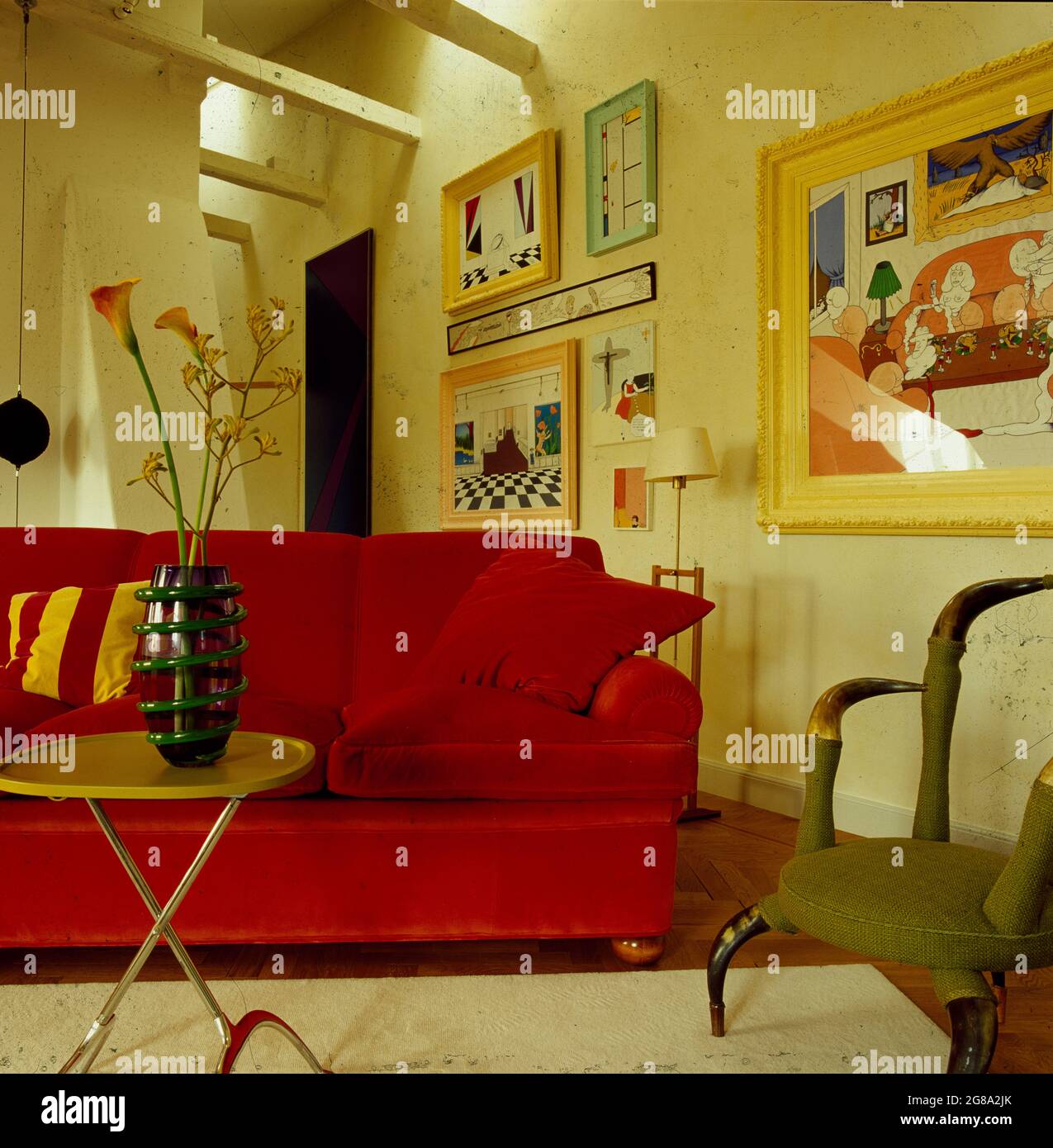Canapé en velours rouge dans la chambre avec murs recouverts de imprimés Banque D'Images