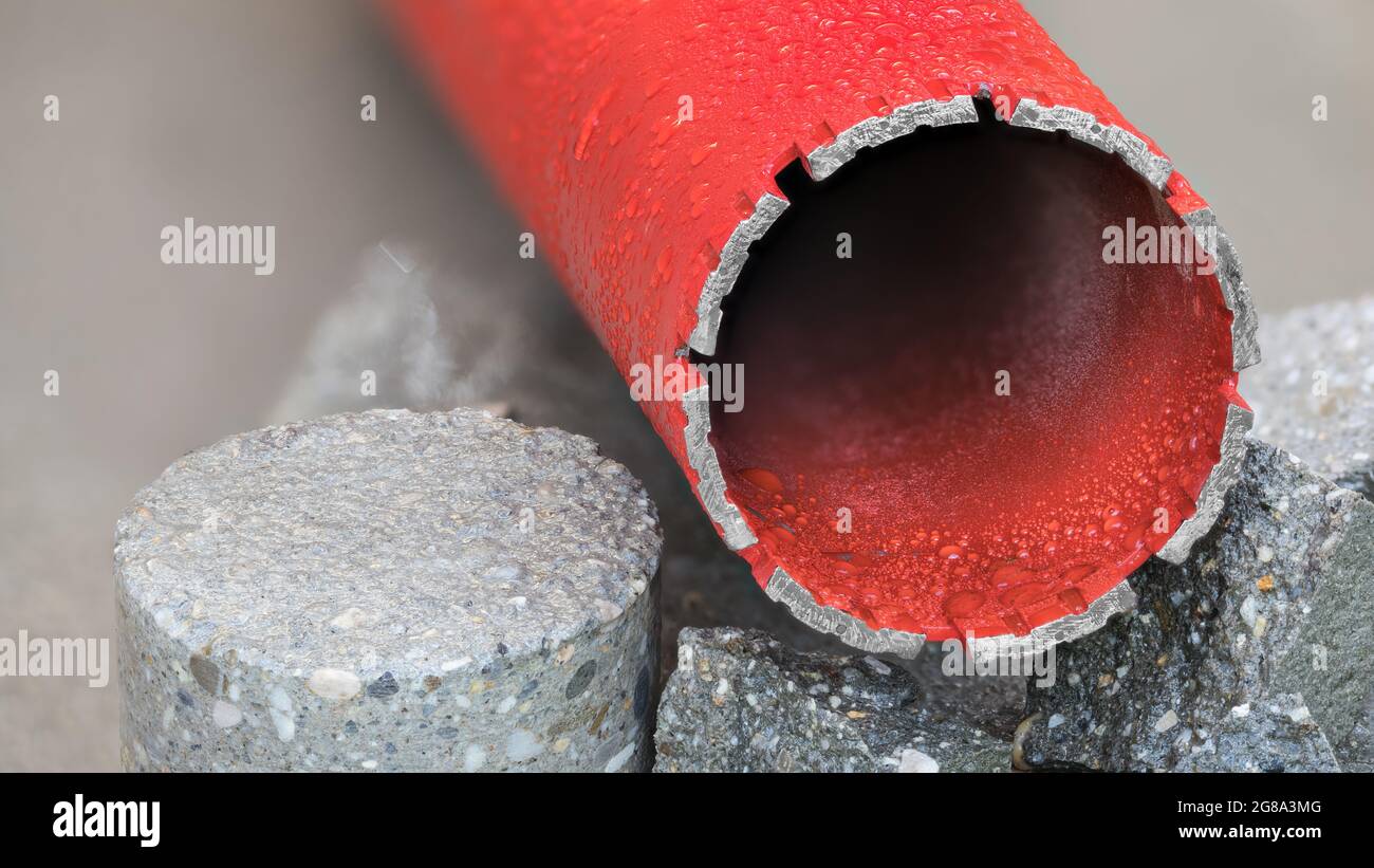 Foret diamant refroidi à l'eau rouge sur un morceau rond alésé de carreaux  de béton gris. Outil pour mouiller le perçage sur la maçonnerie, la pierre  et les matériaux de construction durs