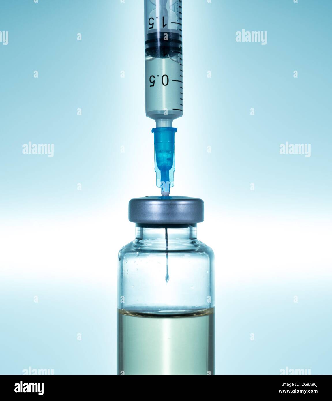 Macro d'une seringue hypodermique ou d'une aiguille remplie de vaccin à partir d'un flacon sur fond d'étoile bleue Banque D'Images