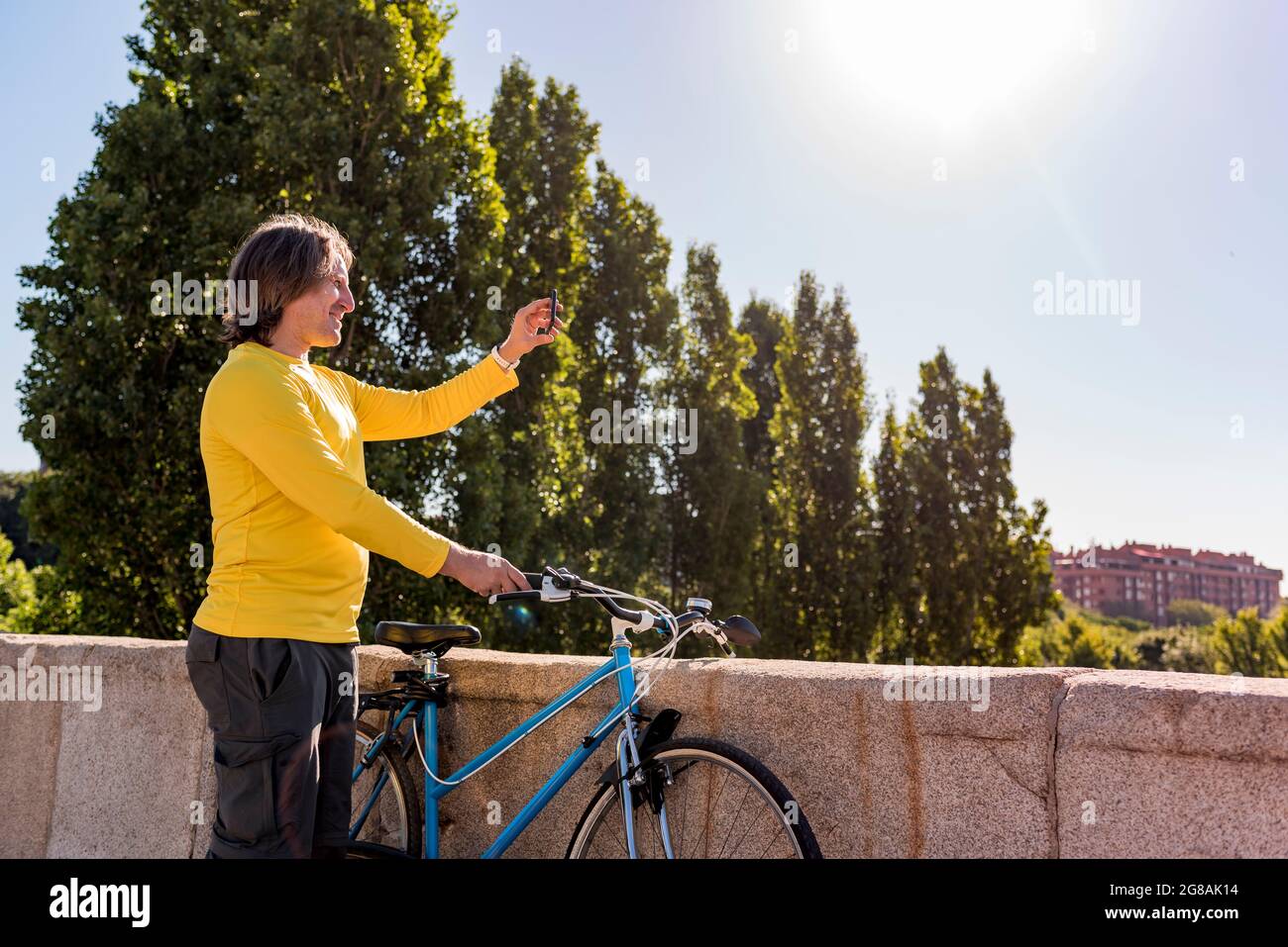 Homme caucasien avec mobile et vélo dans la ville Banque D'Images
