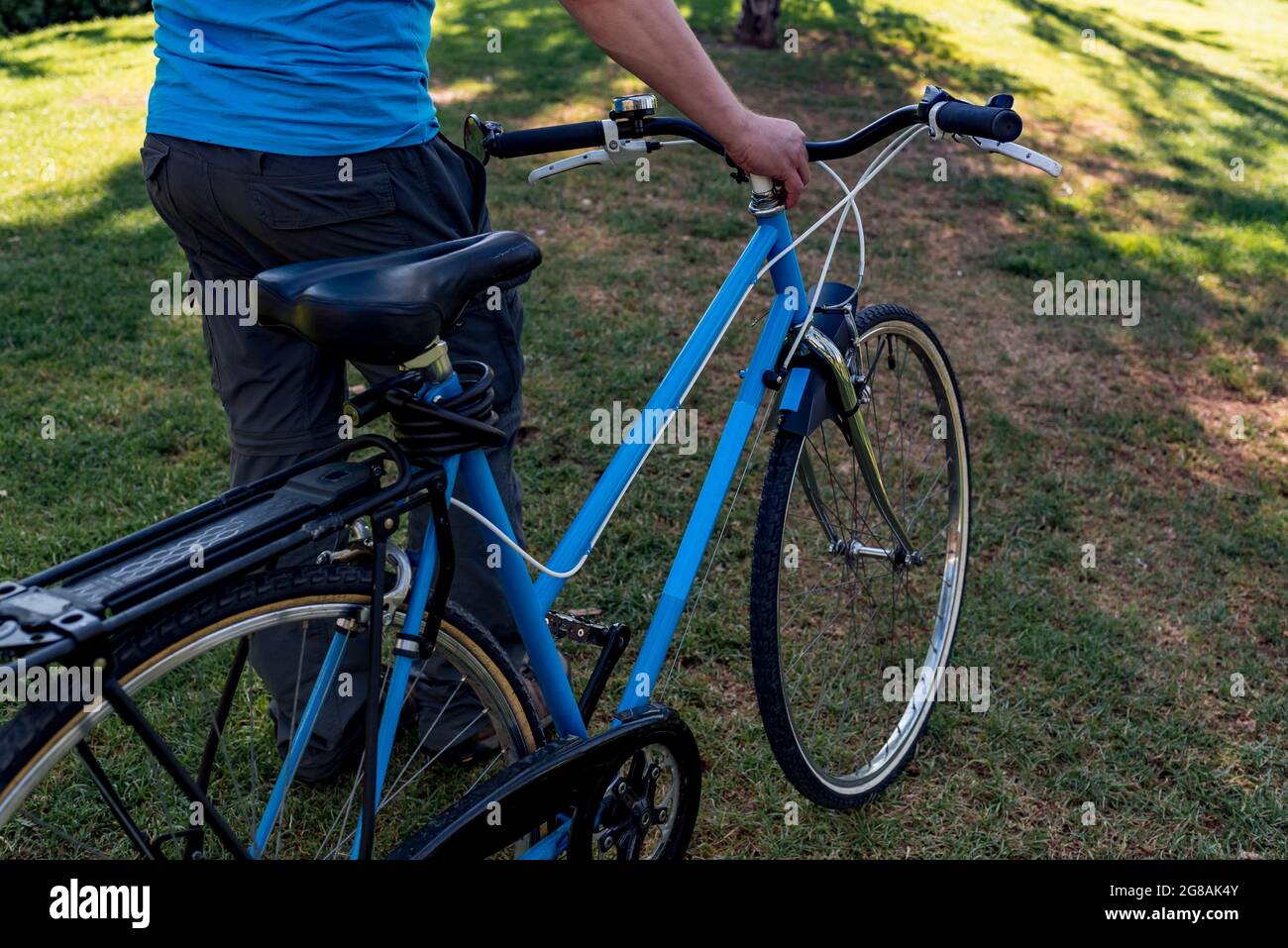Homme méconnaissable marchant dans le parc avec son vélo Banque D'Images