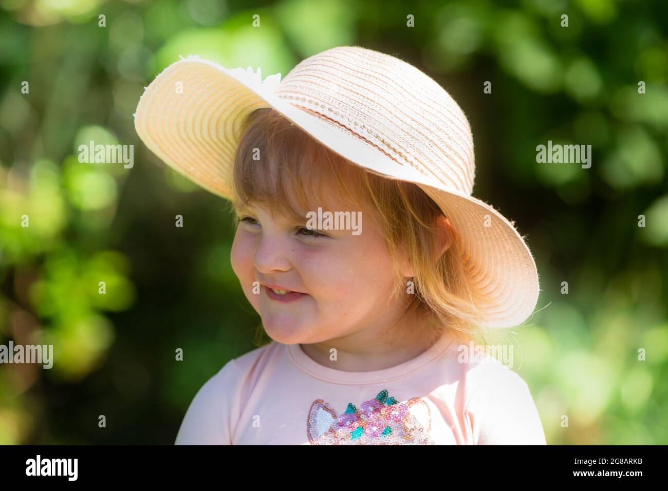 Fille blanche de deux ans, gros plan, portant un chapeau et souriant Banque D'Images