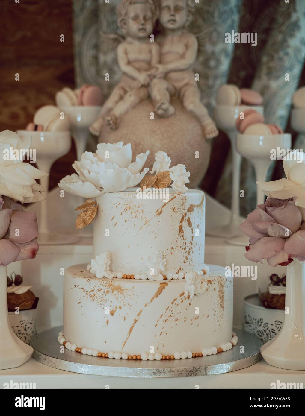 Photo Verticale D Un Delicieux Gateau Blanc Avec Des Biscuits Et Des Statues D Ange Autour Lors D Une Fete D Anniversaire Photo Stock Alamy