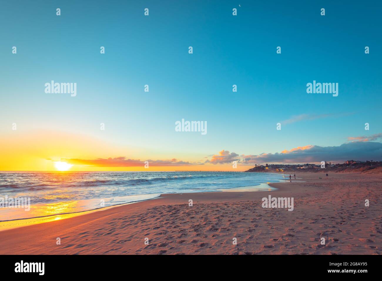 Coucher de soleil spectaculaire avec des personnes pêchant depuis la rive à la plage de Port Noarlunga, Australie méridionale Banque D'Images