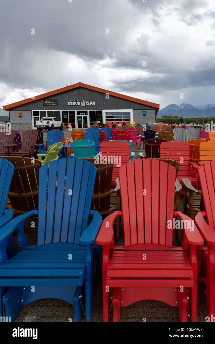 Nombreuses chaises de pelouse aux couleurs vives à vendre à l'extérieur devant un magasin. Banque D'Images