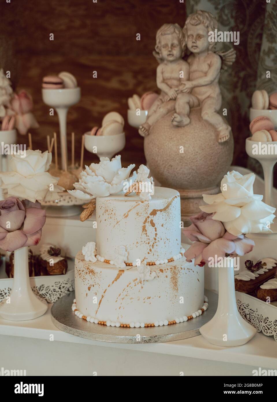 Photo Verticale D Un Delicieux Gateau Avec Des Bonbons Et Des Statues D Ange Autour D Elle Lors D Une Fete D Anniversaire Photo Stock Alamy