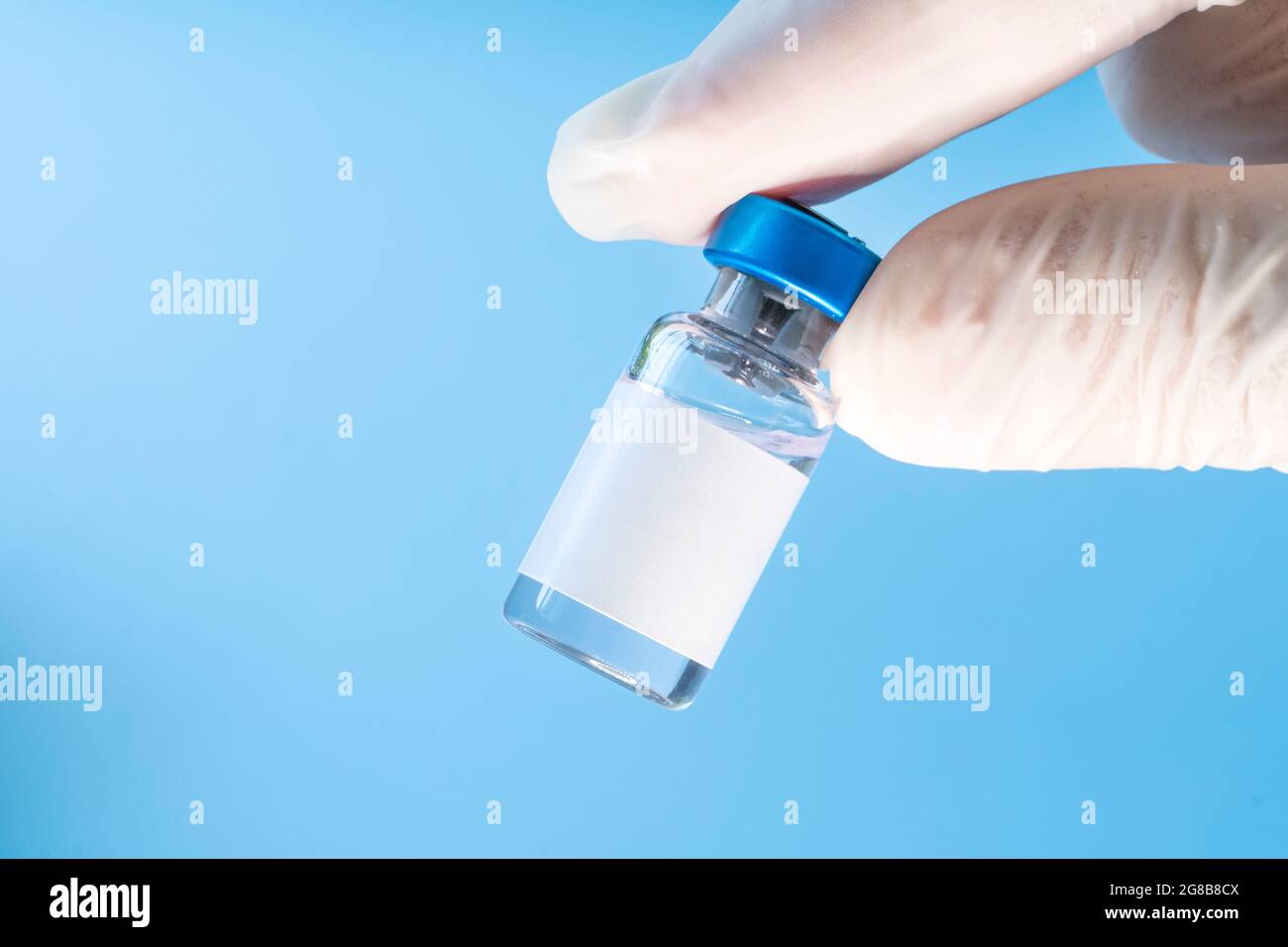 Vaccin en flacon avec seringue sur fond bleu. Étiquette blanche vierge pour le design et le texte Banque D'Images