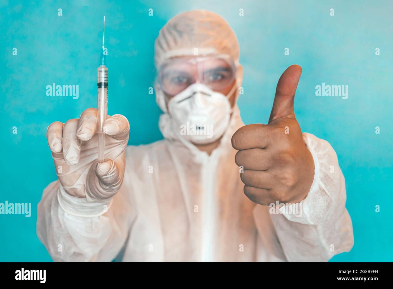 Gros plan d'un scientifique qui interagit avec le vaccin liquide-seringue en laboratoire. Le médecin montre le pouce vers le haut. Le concept de vaccination correcte, bene Banque D'Images