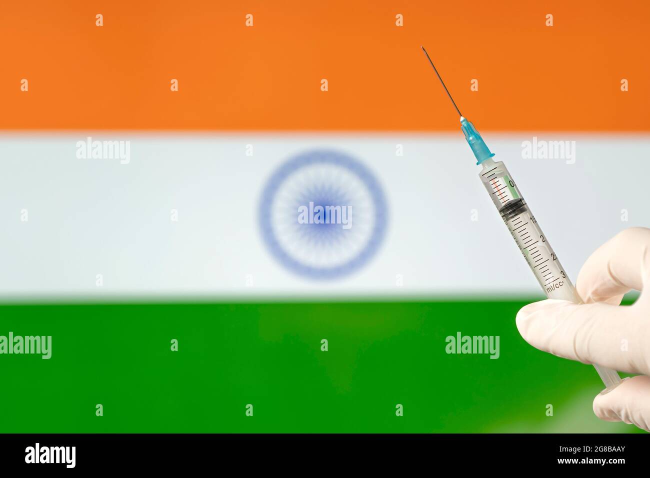 Drapeau indien avec le concept Covid-19 du coronavirus. Médecin avec des gants médicaux de protection blancs portant un vaccin. La rupture du virus Corona. Concept de masse Banque D'Images