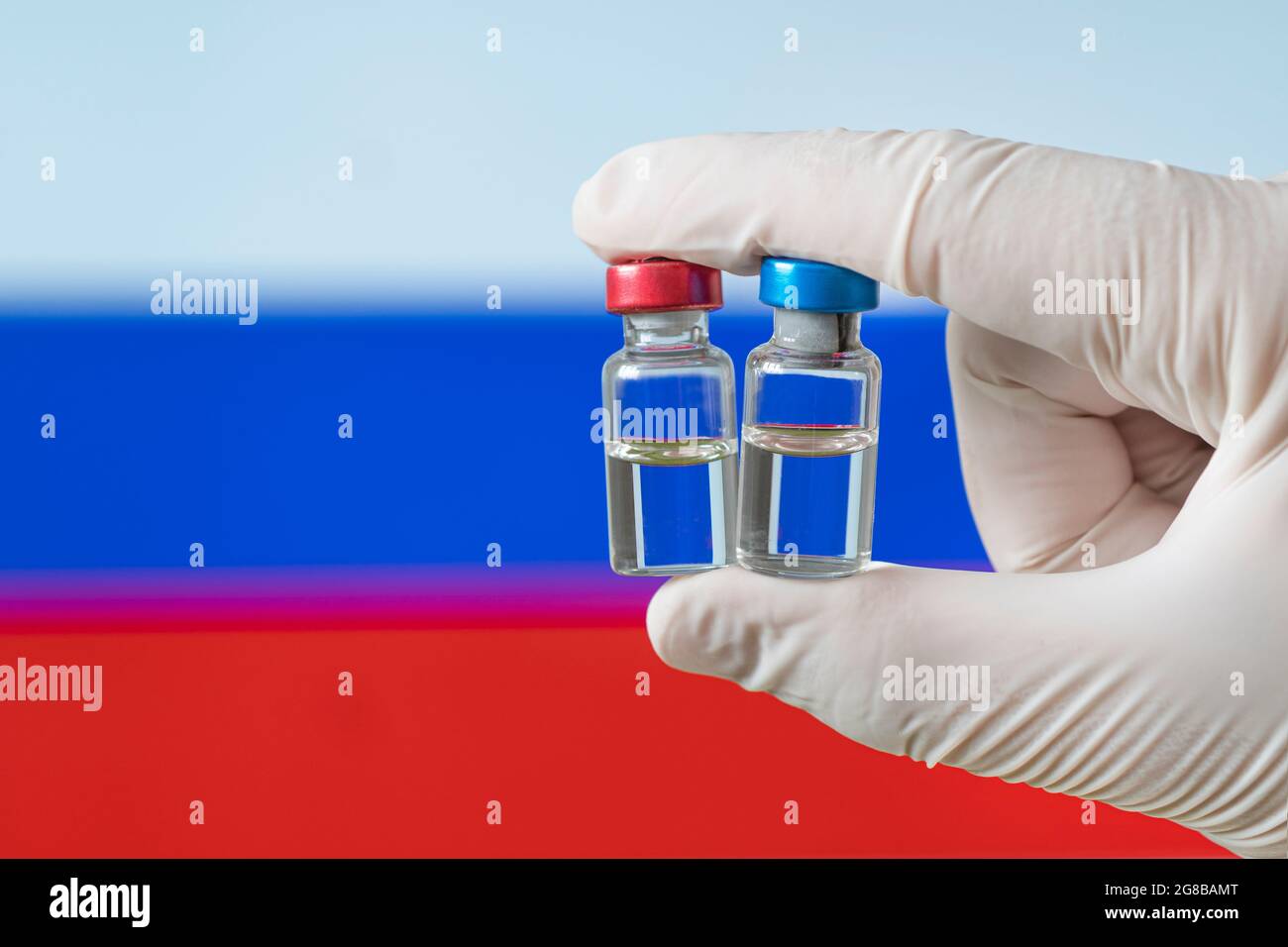 Drapeau russe avec le concept Covid-19 du coronavirus. Médecin avec des gants médicaux de protection tenant une bouteille de vaccin. Corona virus OutBreaking. Concept de ma Banque D'Images