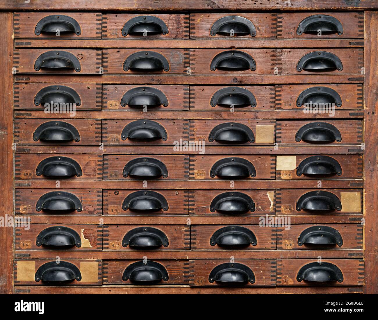 Arrière-plans et textures : armoire en bois très ancienne avec tiroirs à poignées noires, vue avant Banque D'Images