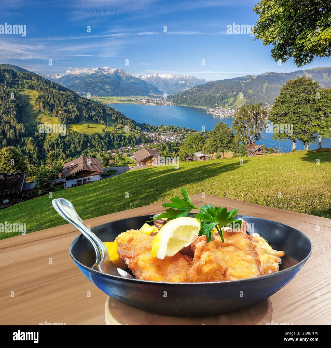 La cuisine autrichienne traditionnelle (Wiener schnitzel) contre Zell am See village avec lac en Autriche Banque D'Images