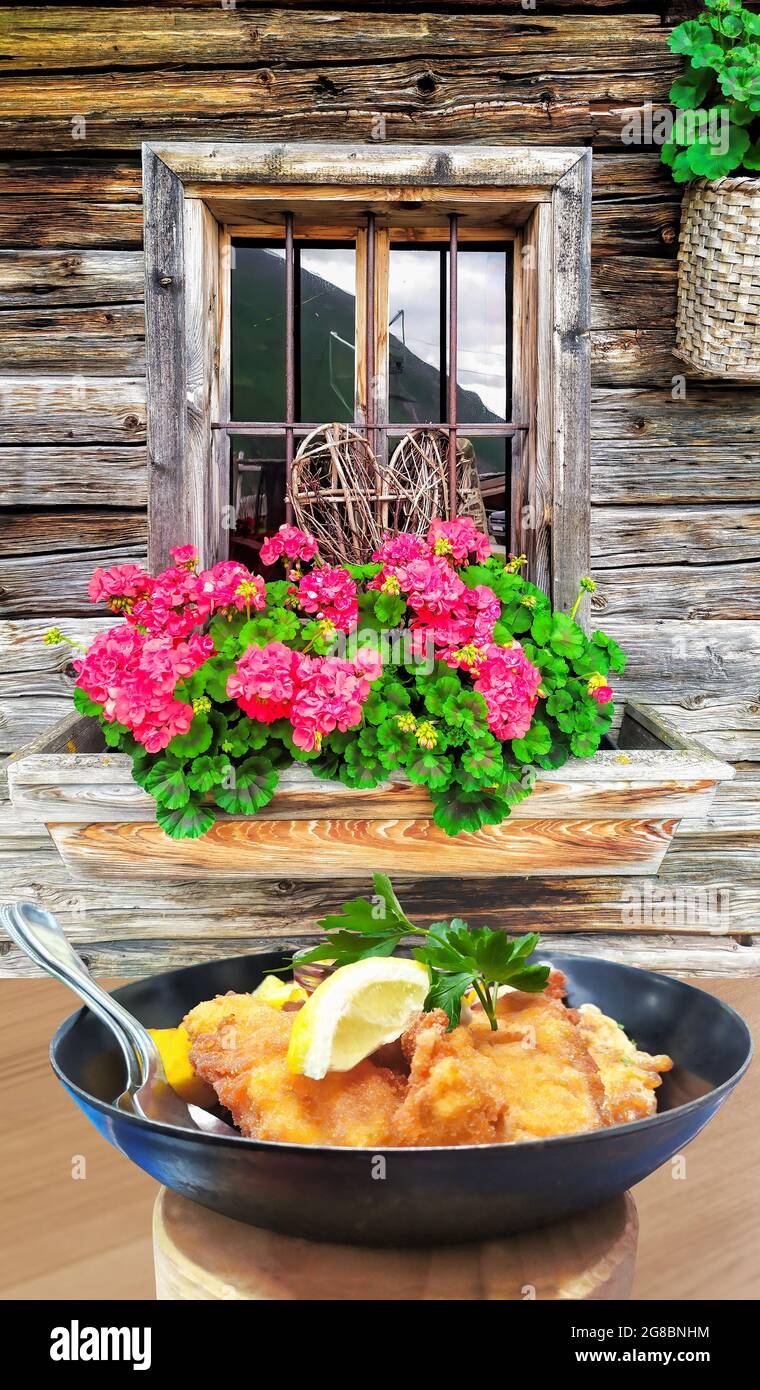 La cuisine autrichienne traditionnelle (Wiener schnitzel) contre le cottage traditionnel à Kaprun, en Autriche Banque D'Images