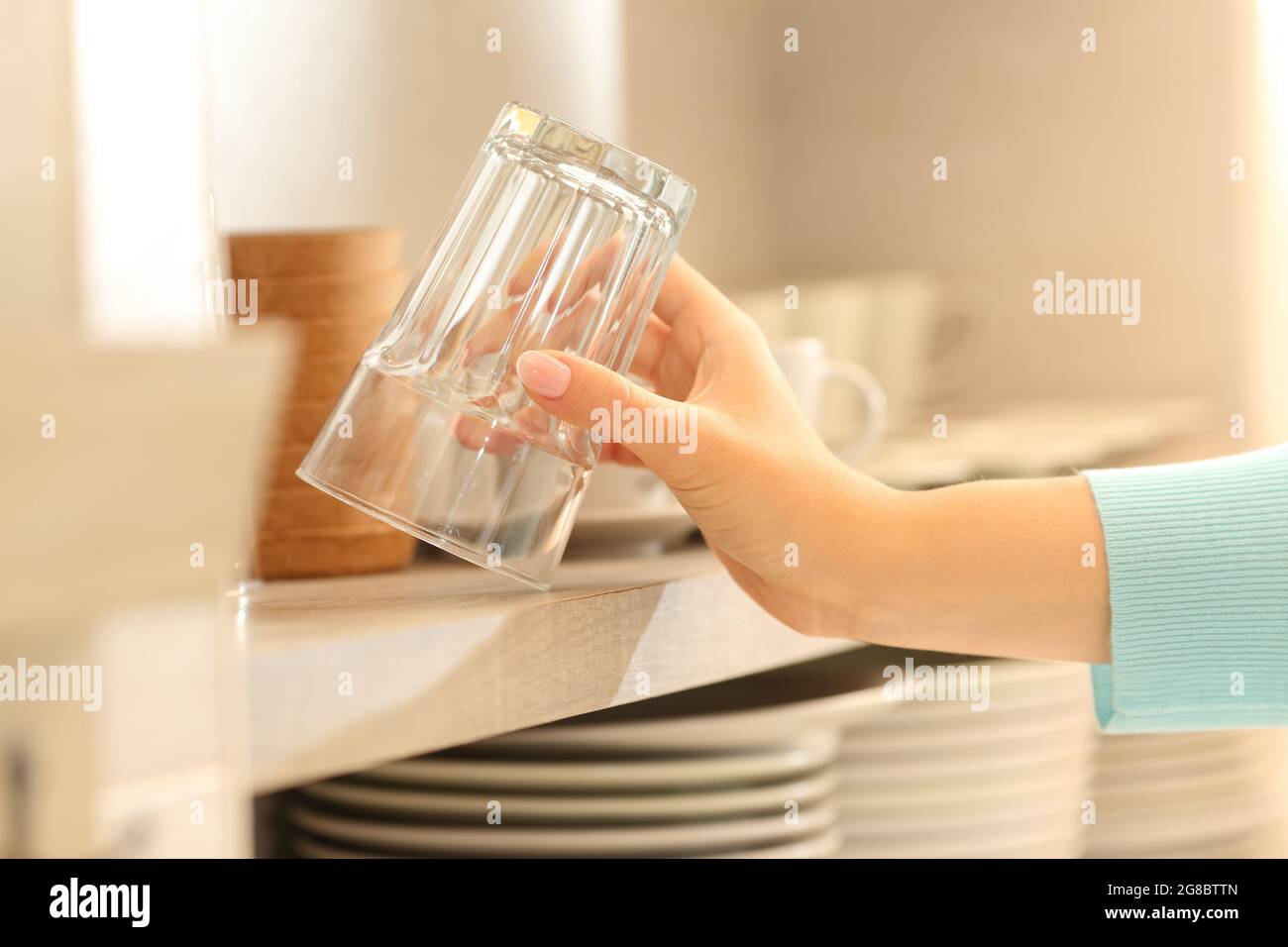 Gros plan d'une femme qui attrape un verre dans la cuisine Banque D'Images