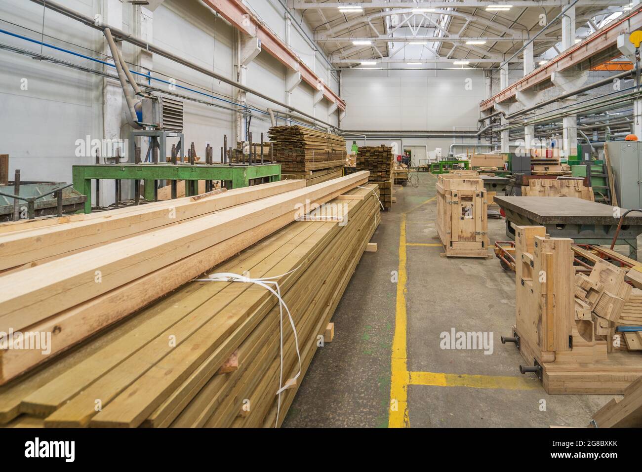 Intérieur typique d'une usine de travail du bois, grand atelier avec machines automatisées et piles de bois. Banque D'Images