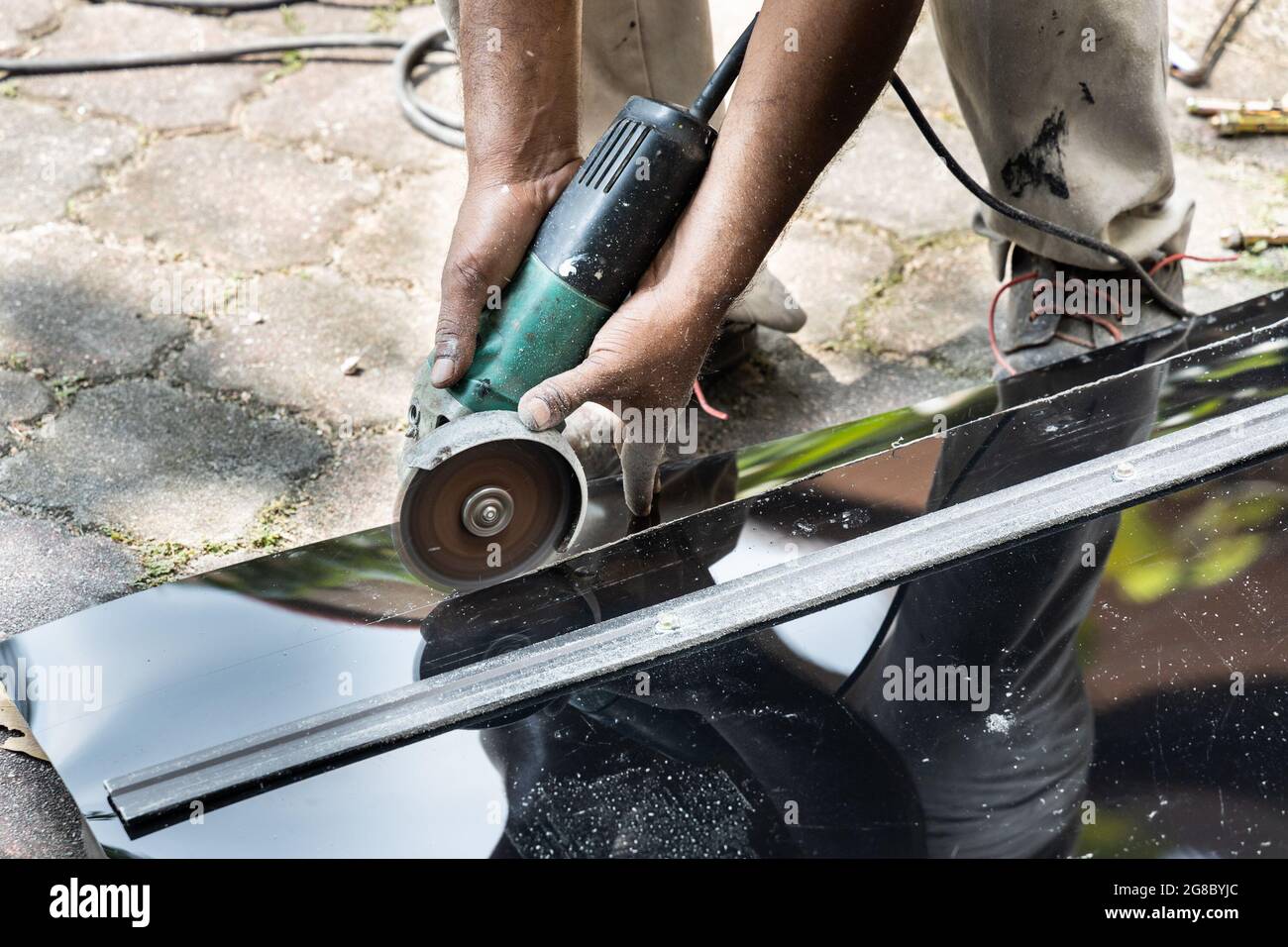 Travailleur coupant la tôle de polycarbonate de toit avec outil de coupe Banque D'Images