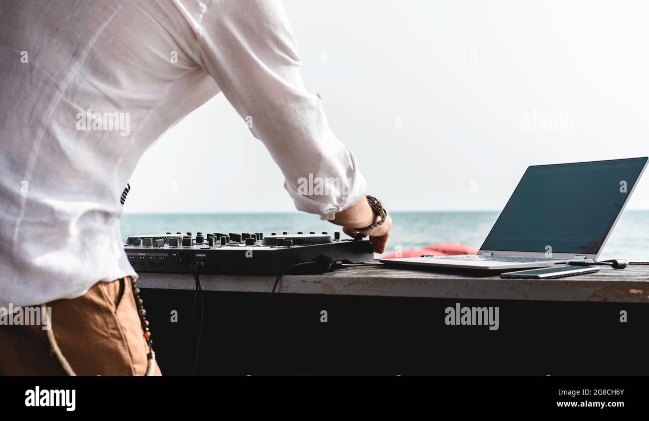 Disc jockey jouant de la musique pour les touristes au club de fête à l'extérieur sur la plage - DJ à la musique live événement - Live événement, musique et divertissement concept - Entert Banque D'Images