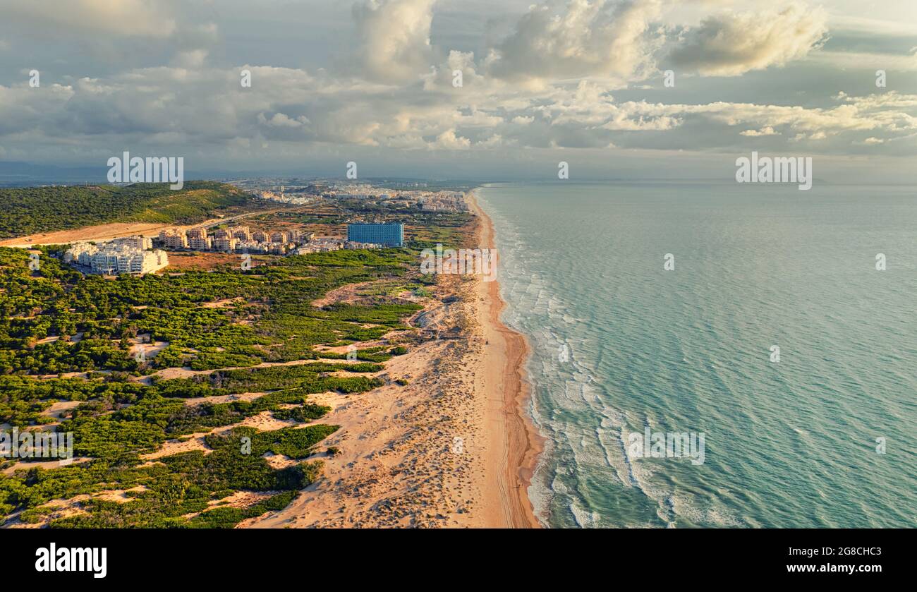 Point de vue de drone aérien plage de sable et mer Méditerranée en début de matinée. El Moncayo, bord de mer de Guardamar. Costa Blanca, Espagne. Vacances d'été Banque D'Images