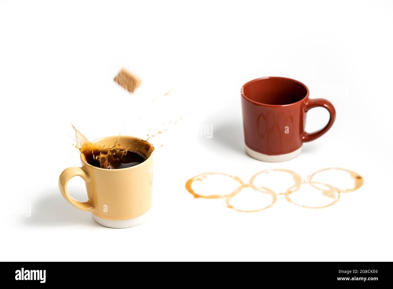 Tasse à café contenant du sucre et anneaux olympiques faits de taches de  café en arrière-plan Photo Stock - Alamy