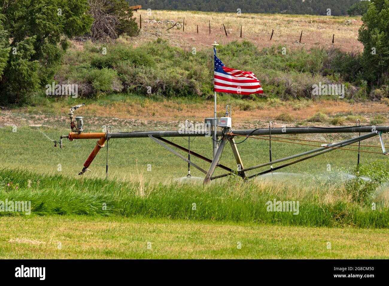 Poncha Springs, Colorado - UN système d'irrigation à pivot central doté d'un drapeau américain. Banque D'Images