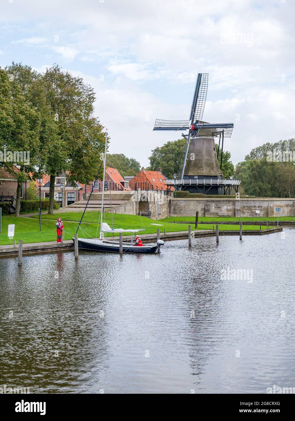 Moulin de Kaai et canal avec petit voilier dans la ville de Sloten, Sleat, à Friesland, pays-Bas Banque D'Images