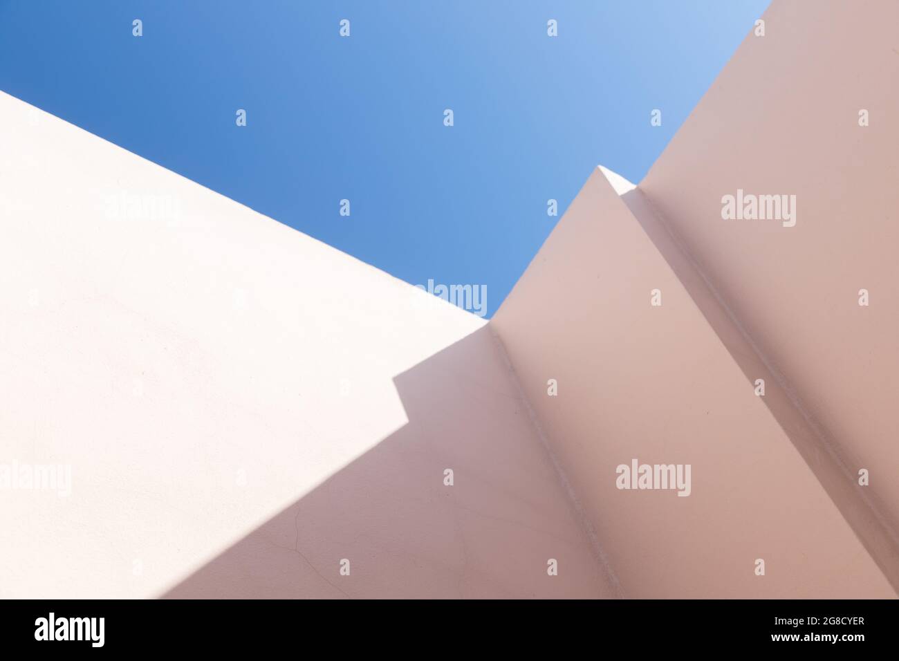 Abstrait fragment d'architecture contemporaine, murs en béton peint rose coin est sous ciel bleu Banque D'Images