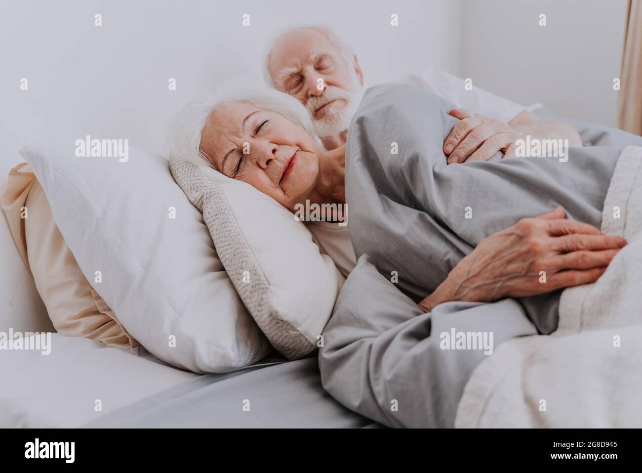 Beau couple senior appréciant le temps ensemble à la maison - personnes âgées dormant dans le lit à la maison Banque D'Images