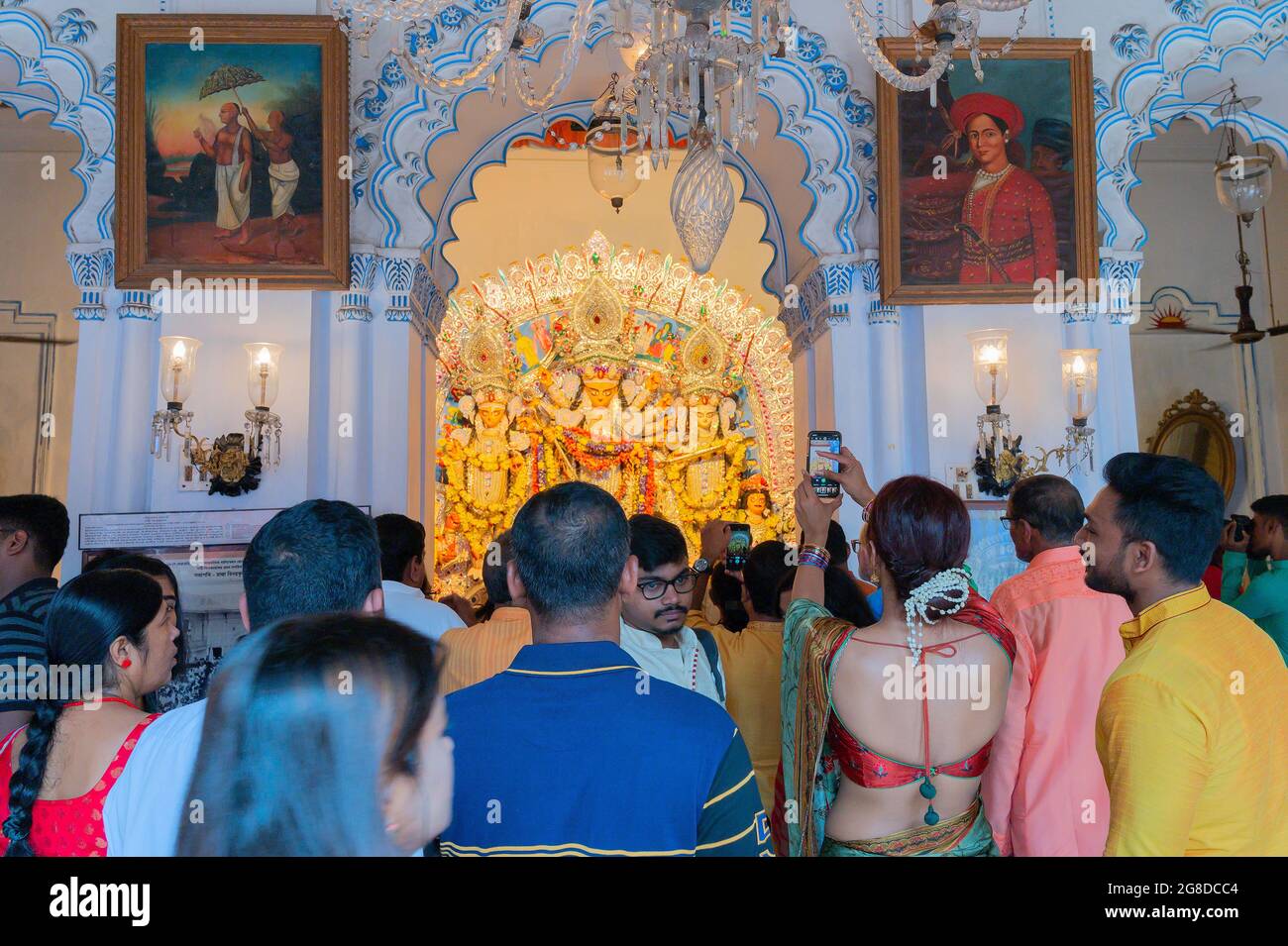 Kolkata, Bengale-Occidental, Inde - 6 octobre 2019 : Dévotée moderne vêtue de sari prenant en photo la Déesse traditionnelle Durga avec sa mobil Banque D'Images