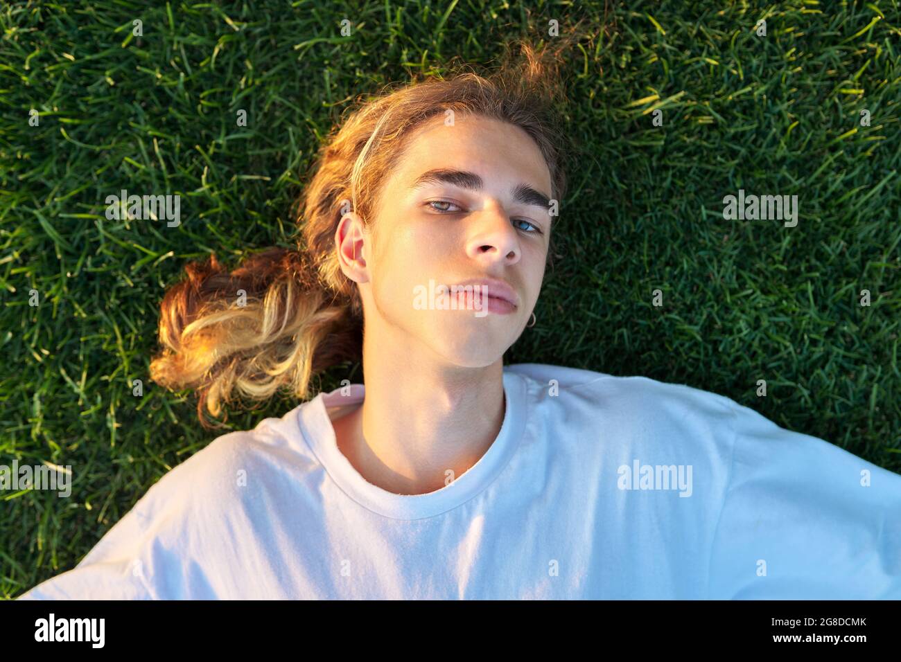 Gros plan sur le beau gars de 16 ans, 17 ans sur l'herbe verte, vue de  dessus Photo Stock - Alamy