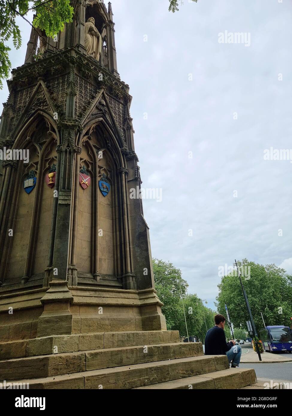 Les touristes et les étudiants s'assoient et se détendent sur les marches du Mémorial des martyrs, un monument en pierre situé à l'intersection de St Giles, de la rue Magdalen et de la rue Beaumont, à l'ouest du Balliol College, Oxford, Angleterre. Il commémore les Martyrs d'Oxford du XVIe siècle. Conçu par George Gilbert Scott, le monument a été achevé en 1843 après deux ans de travail, après avoir remplacé « une vieille maison pittoresque mais chancelante ». Royaume-Uni. Banque D'Images