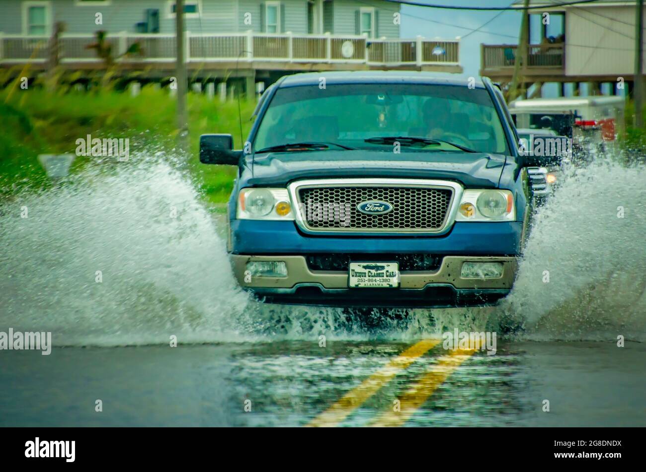 Les conducteurs naviguent sur des routes inondées après de fortes pluies, le 7 juillet 2021, à Dauphin Island, Alabama. Banque D'Images