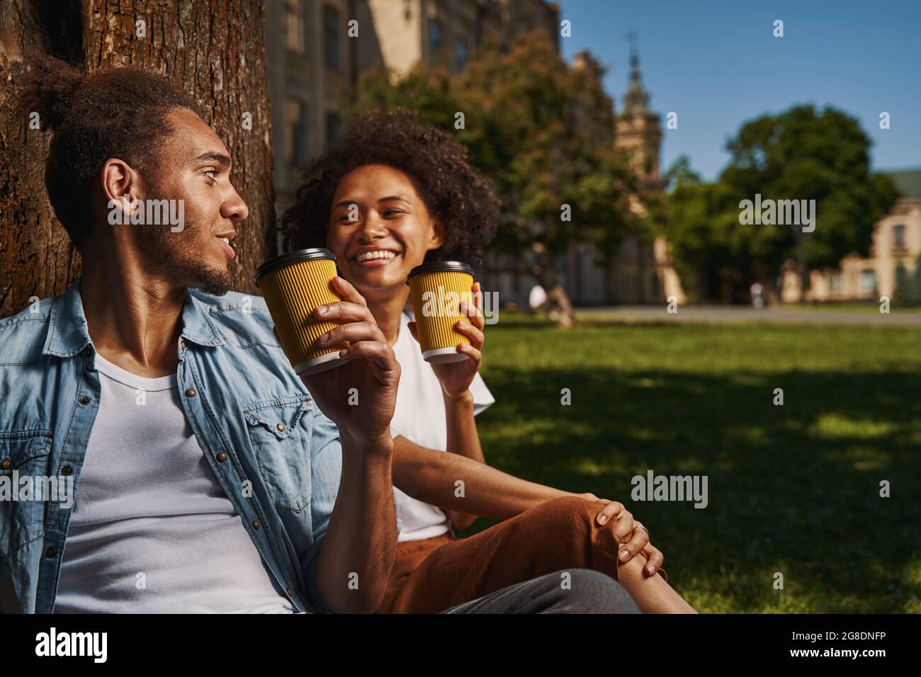 Couple heureux de déguster un café chaud à l'extérieur et de l'air détendu Banque D'Images