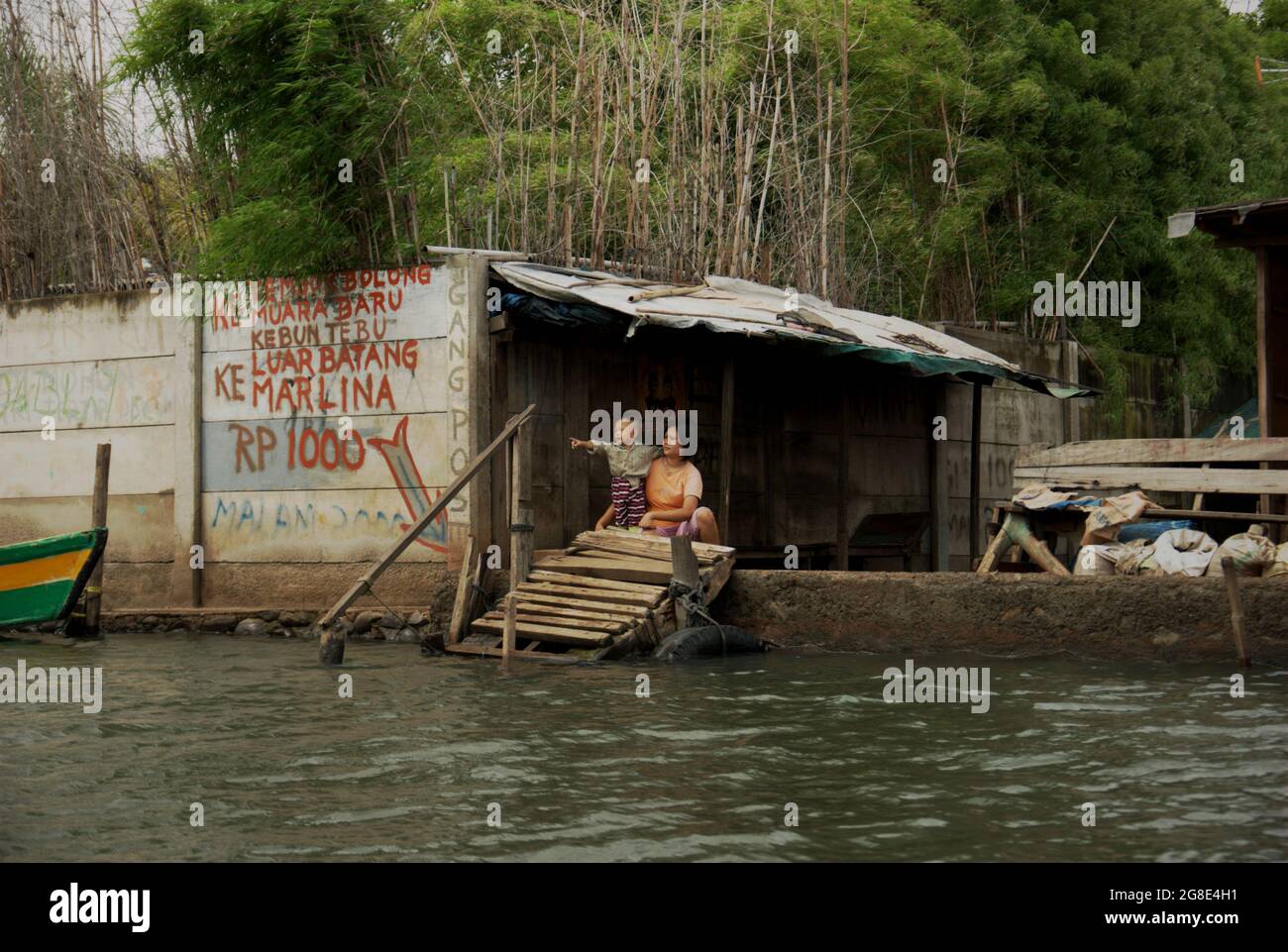 Une femme et un enfant dans un terminal de transport par bateau reliant les colonies côtières au port de Sunda Kelapa dans la zone côtière de Jakarta, en Indonésie. Banque D'Images