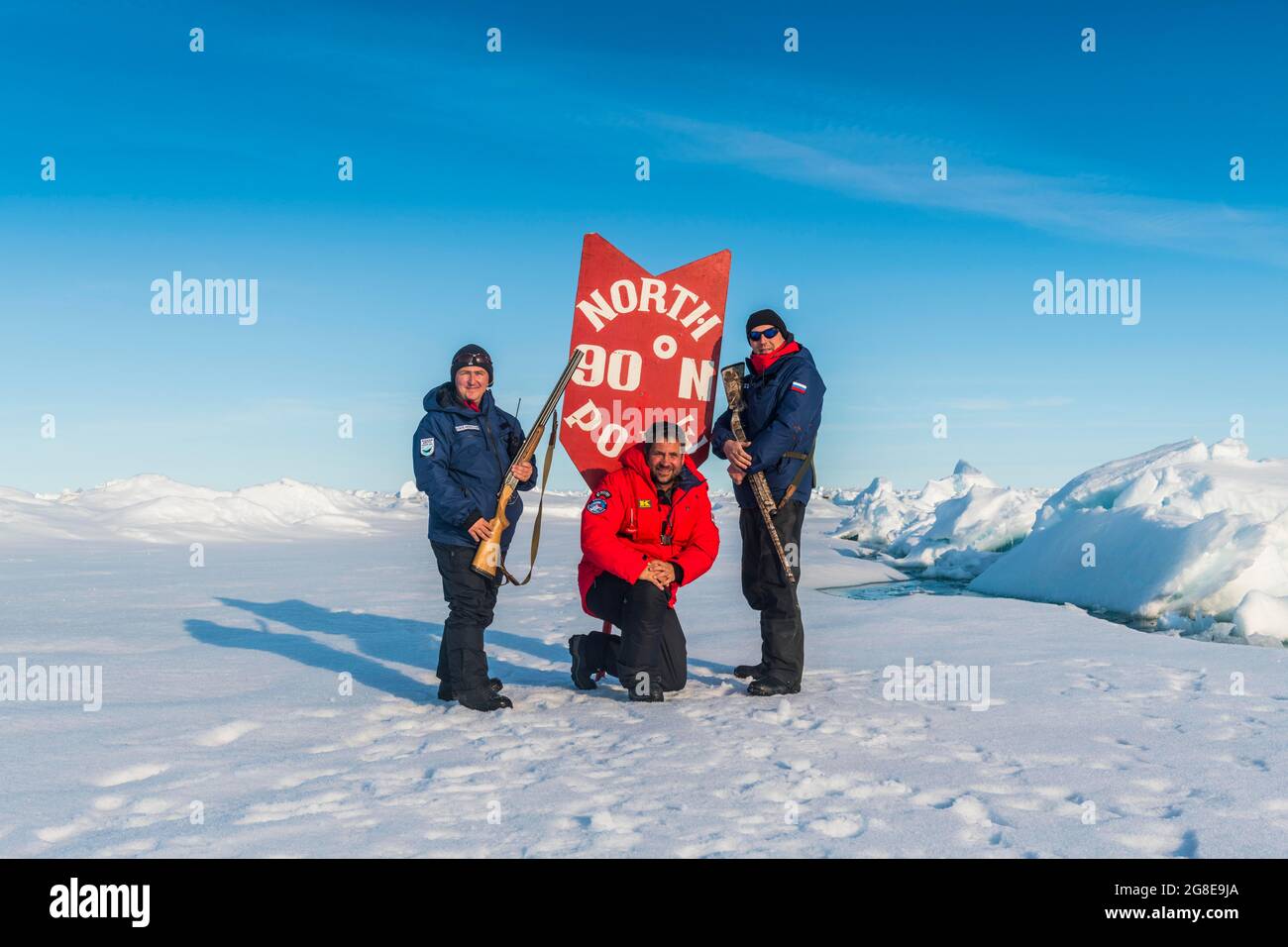 Homme posant avec un panneau sur le pôle Nord, Arctique Banque D'Images