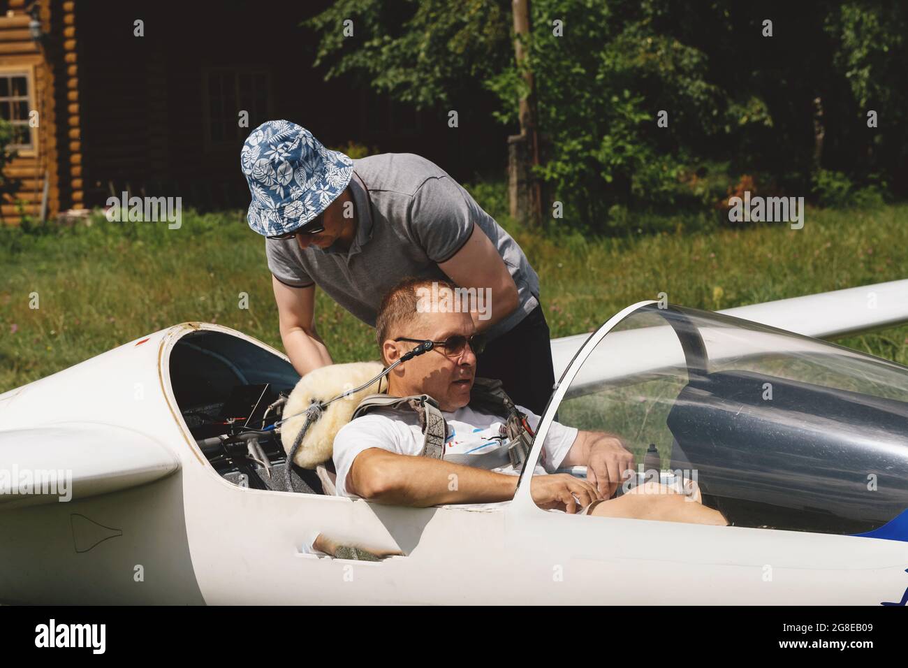 Un club qui s'évolte, prêt pour le vol à bord d'un avion de planeur. Petit sport d'aviation. Deux personnes vérifient le tableau de bord de l'habitacle d'un avion d'époque Banque D'Images