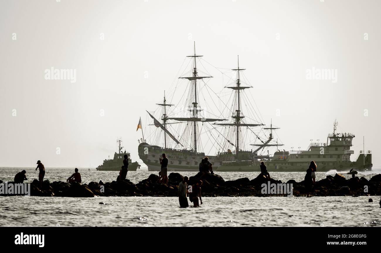 Silhoutte de touristes dans le golfe finlandais, reconstruit le navire à canon Poltava en arrière-plan, parc du 300e anniversaire de Saint-Pétersbourg, Russie Banque D'Images