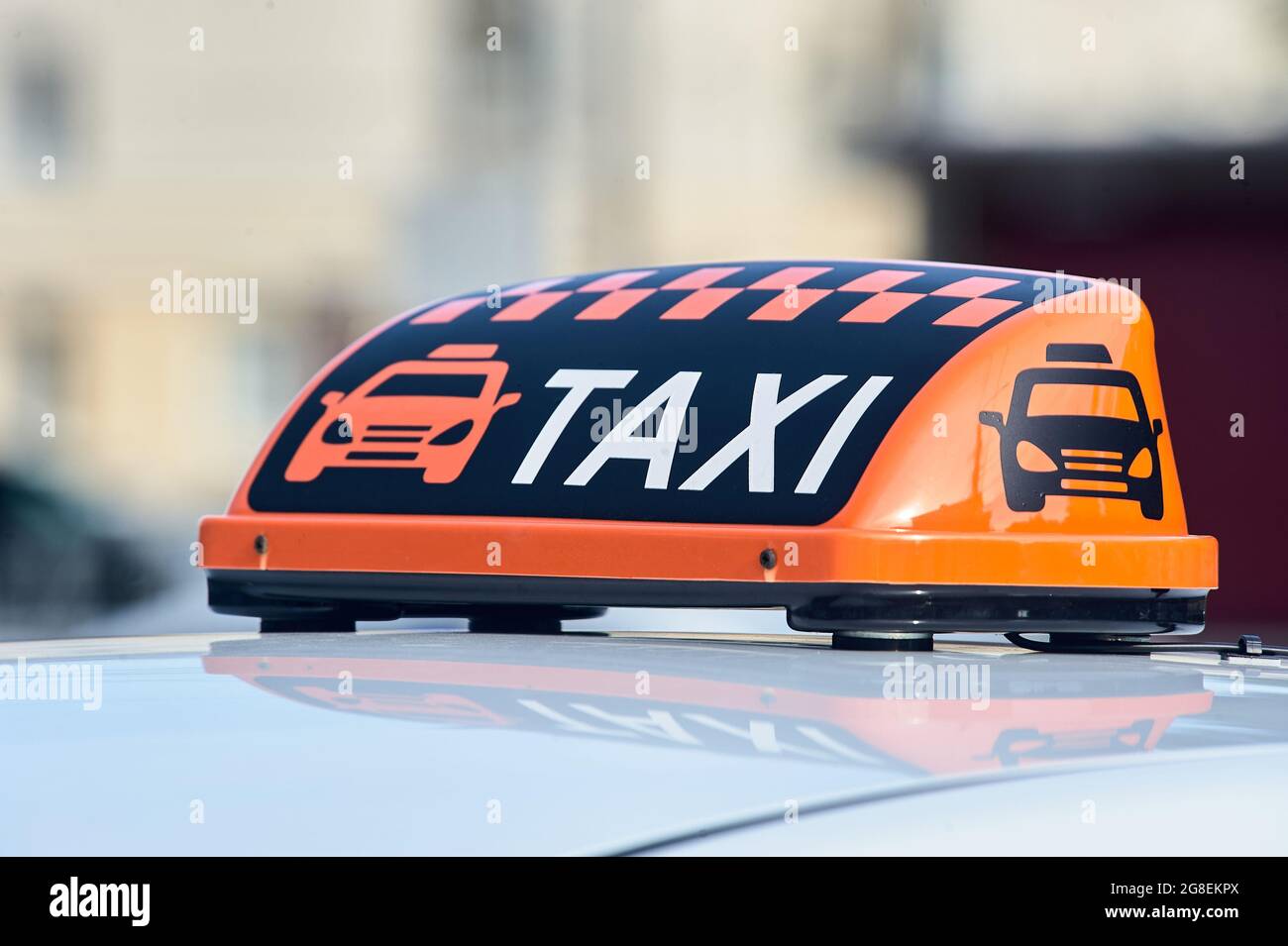 un panneau de taxi orange se trouve sur le toit de la voiture Banque D'Images