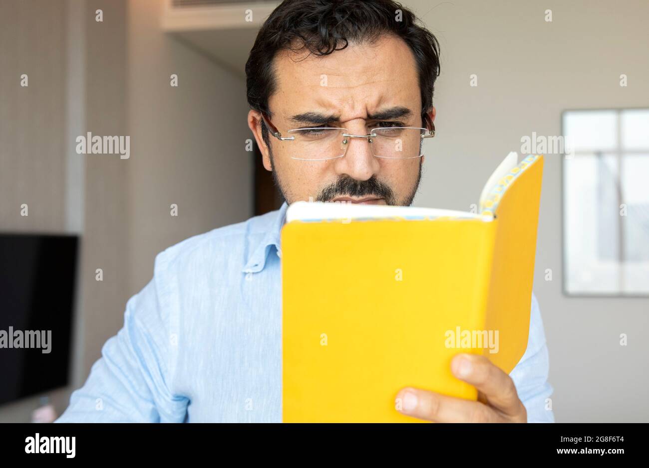 homme d'âge moyen avec mauvaise vue essayant de lire des notes Banque D'Images