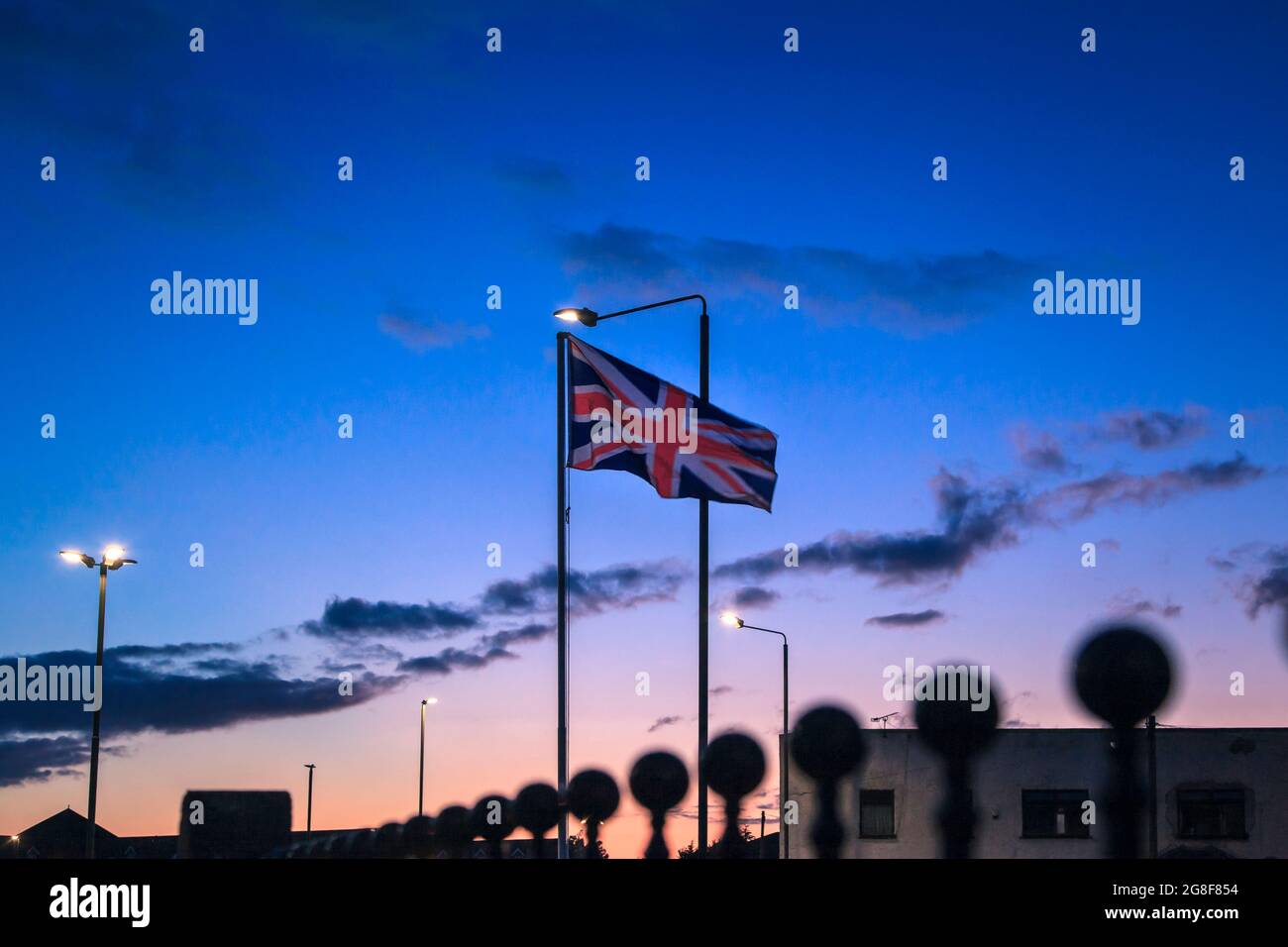 Drapeau britannique qui agite au coucher du soleil dans la ville de long Eaton, à Notinghamshire, Angleterre, Royaume-Uni, Europe Banque D'Images