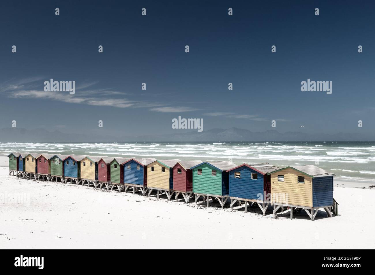 Célèbres maisons de plage colorées à Muizenberg près de Cape Town, Afrique du Sud avec des montagnes Hottentots Holland dans le fond contre le ciel bleu Banque D'Images