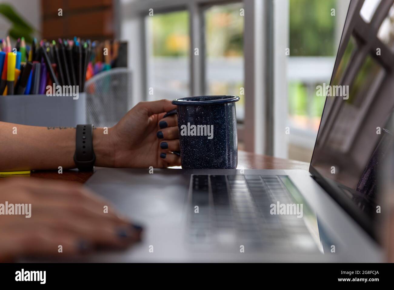 attention sélective sur les mains d'une femme avec une tasse de café, assis dans le bureau à domicile Banque D'Images