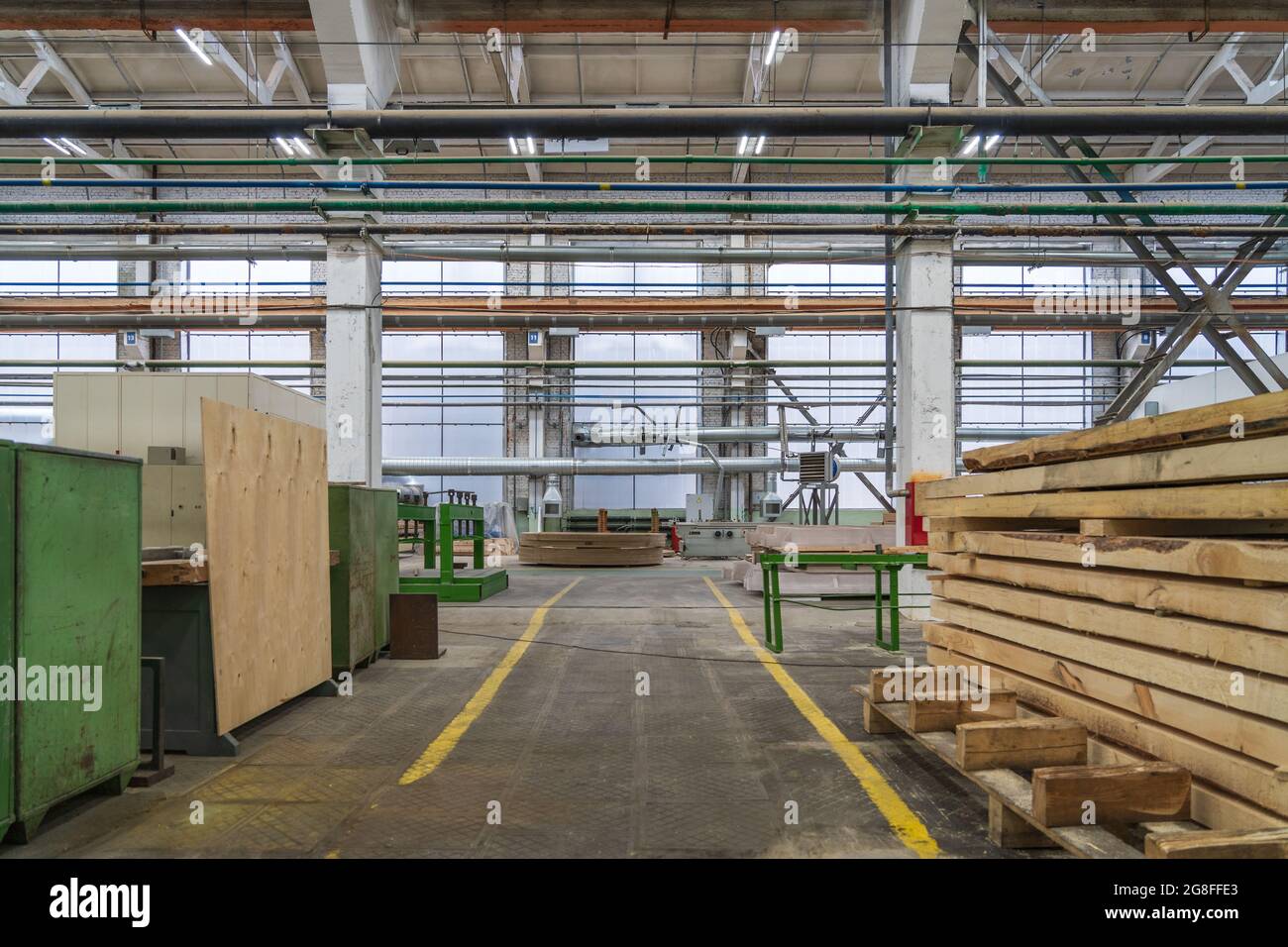 Intérieur typique d'une usine de travail du bois, grand atelier avec machines automatisées et piles de bois. Banque D'Images