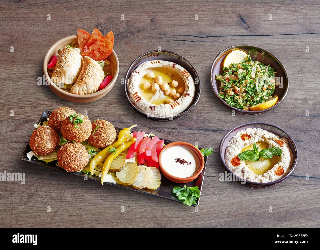 Cinq assiettes et bols avec hors-d'œuvre de mezze sur fond de bois Banque D'Images