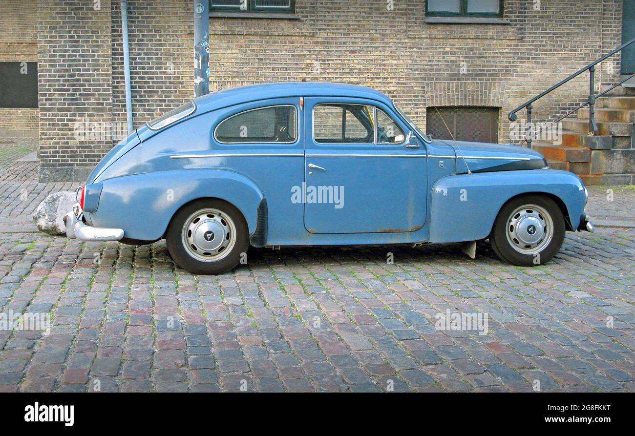 Une Volvo PV544 bleu vintage garée sur une rue pavée. Banque D'Images