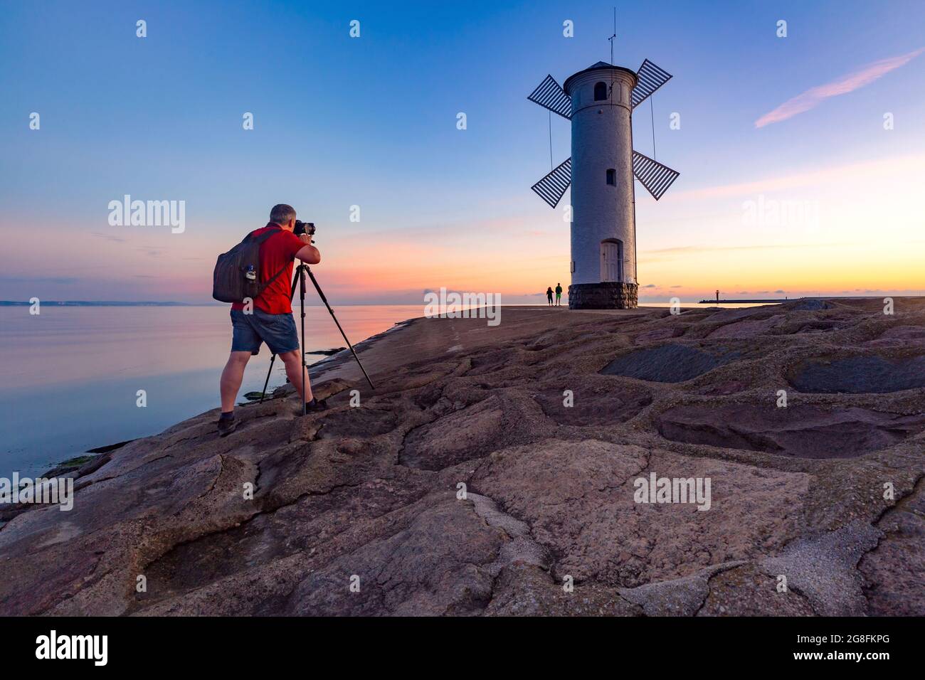 Le photographe prend une photo Stawa Mlyny au coucher du soleil, symbole officiel de Swinoujscie, Pologne Banque D'Images