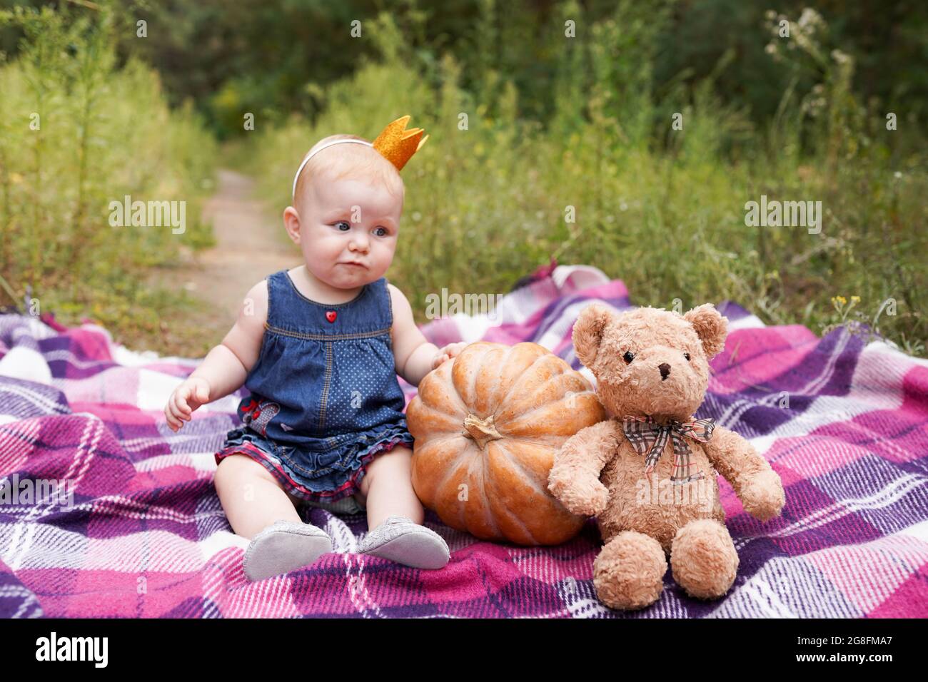 Adorable petite fille de bébé s'amuser avec la citrouille et jouet ours en peluche sur belle journée d'automne dehors. Enfant heureux jouant dans le parc d'automne Banque D'Images