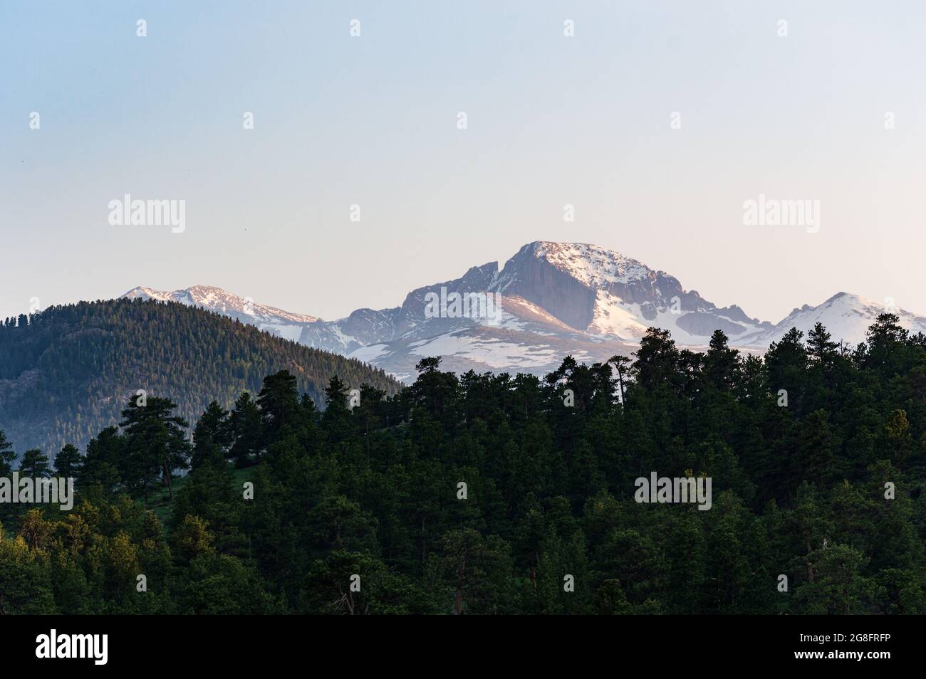 Paysage de montagne vue de long's Peak au coucher du soleil avec Forêt sombre des arbres dans le fond et lumière spectaculaire Banque D'Images