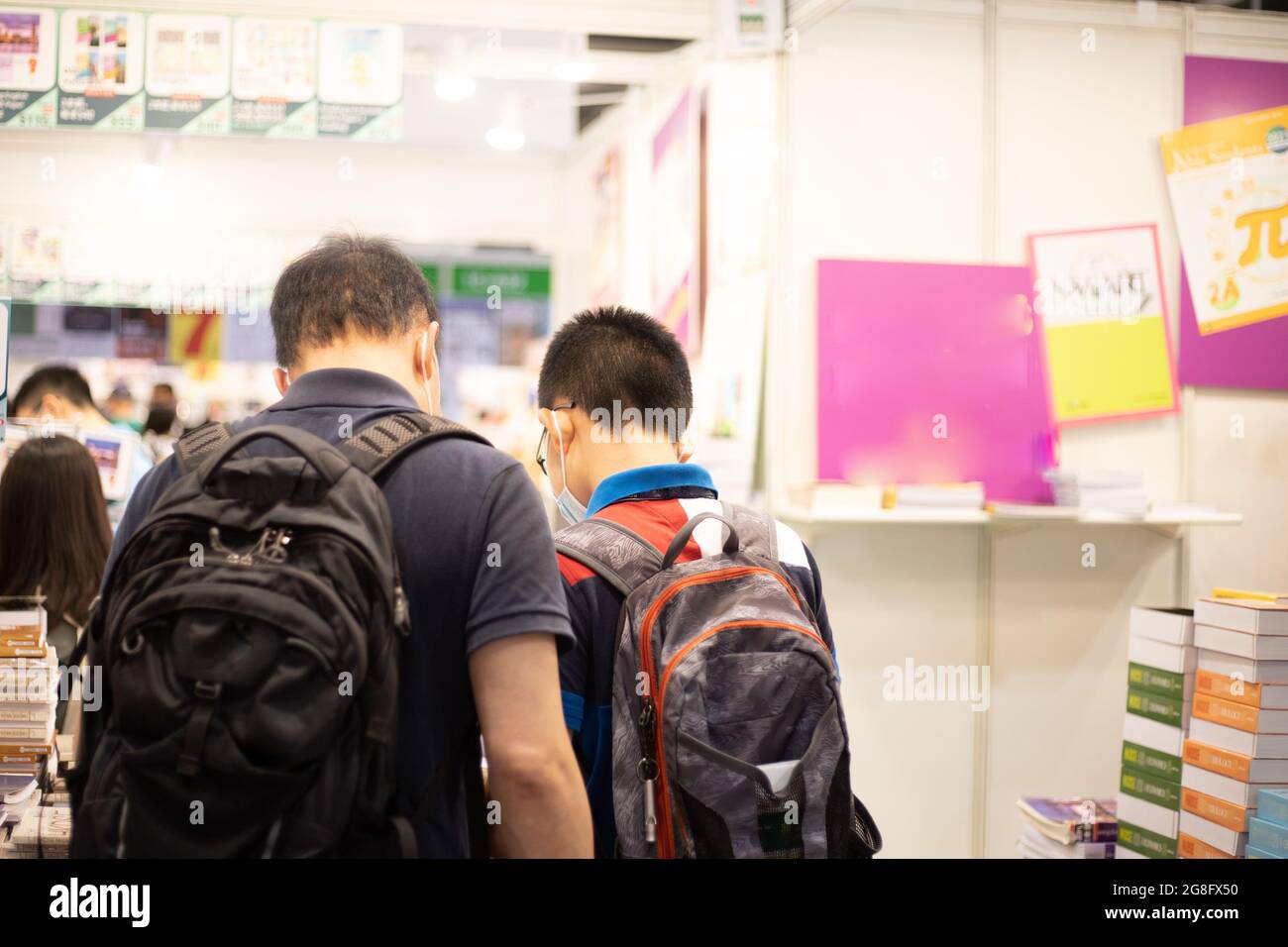 Les personnes ayant des masques de visage lisent et achètent des livres à Hong Kong Book Fair au Hong Kong Convention and Exhibition Centre , WAN Chai pendant Covid-19 Banque D'Images