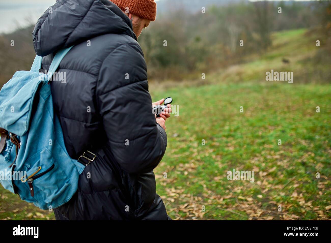 Voyageur homme avec sac à dos avec boussole à la main sur un fond de  montagnes rivière de la nature, concept de voyage, voyage de camping, GPS,  orientation, navigation Photo Stock -